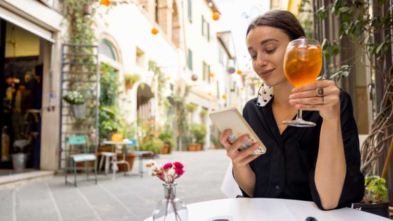 Woman recording qual video on phone in restuarant